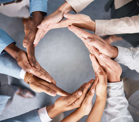 Solidarity makes the world go round. Shot of a group of businesspeople joining hands in solidarity.の写真素材