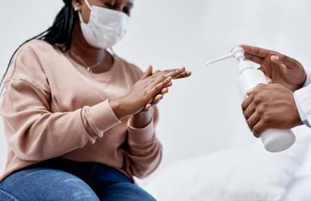 Clean hands keep us from spreading viruses. Closeup shot of an unrecognisable doctor giving hand sanitiser to a patient.の写真素材
