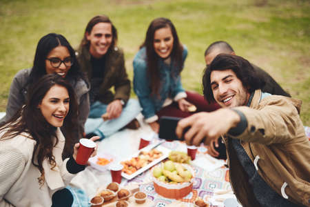Everyone get in for the photo. Shot of a group of young friends taking a self portrait together...
