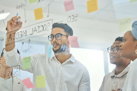 Coming up with a winning strategy. Cropped shot of a group of diverse young businesspeople working...