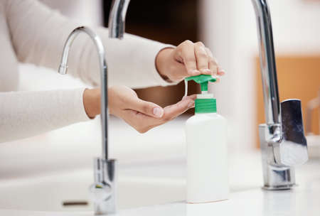 Dont forget to use soap. Shot of an unrecognizable person washing her hands with soap at home.の写真素材