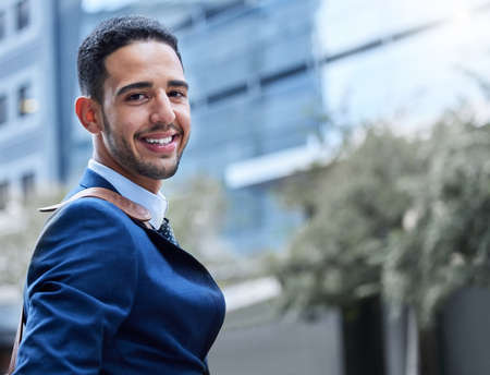Smiling my way towards success. Cropped portrait of a handsome young businessman on his morning commute into work.の写真素材