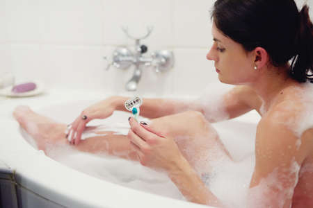 Lather up and shave. Cropped shot of a young woman shaving her legs while in the bath.の写真素材