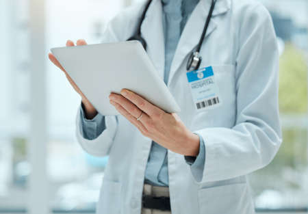 Where is she. Shot of an unrecognizable doctor using a digital tablet at work.