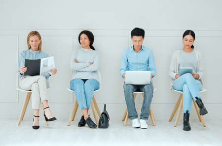 The wait is killing me. Shot of a group of businesspeople waiting in line at an office.の写真素材