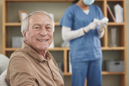 Hes happy to be getting the best healthcare. Shot of an unrecognizable female nurse having a checkup with an elderly patient at home.の写真素材