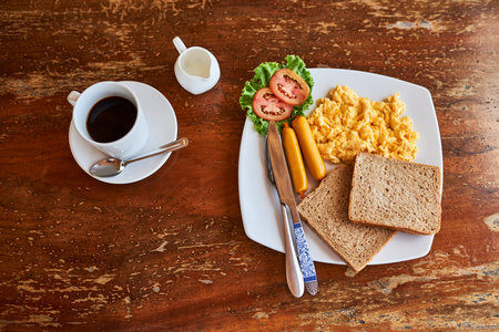 Good mornings start with a great breakfast. High angle shot of a cup of coffee and freshly made breakfast on a table.の写真素材