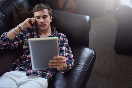 Sure. Im logging in right now. High angle shot of a handsome young man using his tablet and...