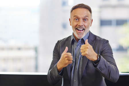 All I do is win, win, win. Shot of a mature businessman showing thumbs up.の写真素材