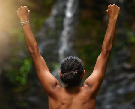 Jungles are the best. Rearview shot of an unidentifiable person celebrating a victory in the jungle.の写真素材