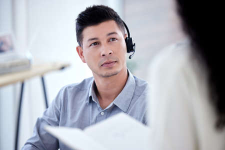 Brainstorming the best route to follow for an issue at hand. Shot of a young call centre agent having a discussion with a colleague in an office.の写真素材