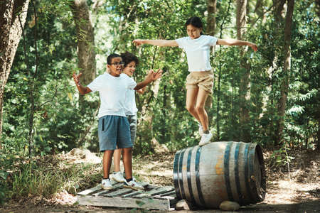 If your childhood looked like this, you had an awesome one. Shot of a group of teenagers having fun with a barrel in nature at summer camp.の写真素材