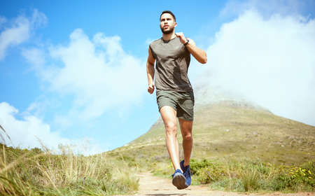 Build a strong mindset and the body will follow. Low angle shot of a sporty young man running...