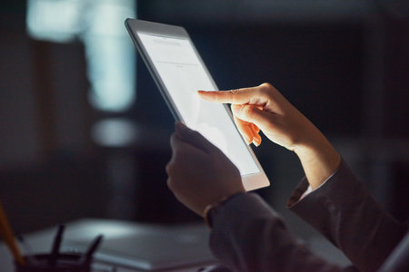 Let your finger do all the work. Cropped shot of an unrecognizable businesswoman using a tablet in the office.の写真素材