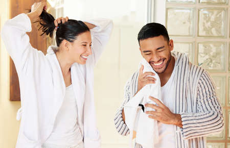 Every day is a good day if you start it right. Shot of a happy young couple going through their morning routine at home.の写真素材