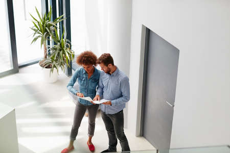 Running through the latest reports. Shot of two colleagues having a discussion in an office.