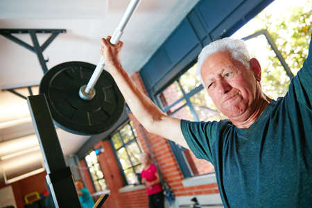 Be mentally stronger than what you physically feel. Shot of a senior man doing weight training at the gym.の写真素材