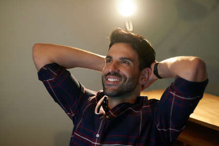 Time to kick back after a successful day. Cropped shot of a young businessman taking a break while...