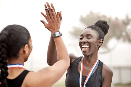 Youre my babe for life. Shot of two athletes high fiving one another.の写真素材