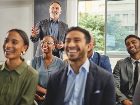 They always enjoy his presentations. Shot of a group of businesspeople having a meeting in a...