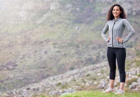 The mountains called and I answered. Shot of a fit young woman out in the mountains for a workout.の写真素材