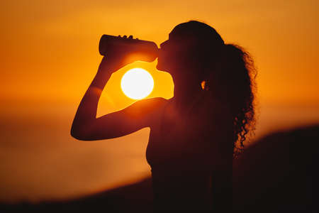 Stay hydrated. Cropped shot of an unrecognizable and athletic young woman drinking water while...