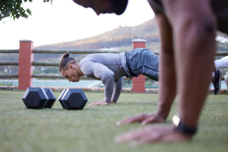 Having a workout partner pushes me to do better. Shot of two men working out and doing pushups...