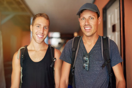 Travel partners and best buddies. Portrait of two smiling young friends wearing backpacks traveling...