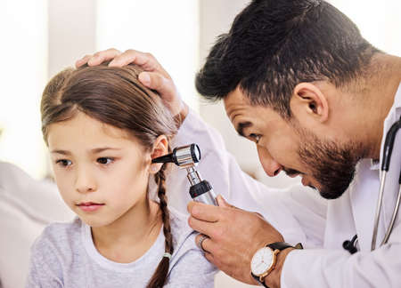 The Doctor is checking my ears today. Shot of a doctor using an otoscope to examine a little girls...