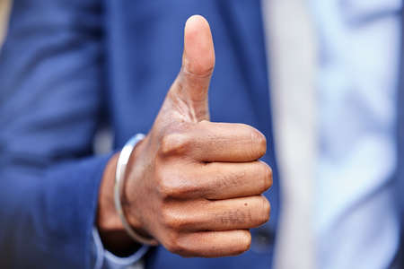 Positivity is the key. Shot of an unrecognizable businessman showing thumbs up.