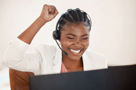 Ill earn extra commission on this one. Shot of a young call centre agent cheering while working on a...