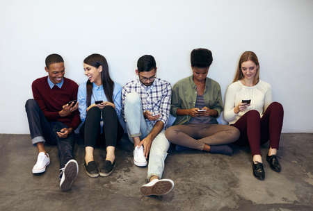 Catching up on our social networking. Shot of university students social networking in a campus...
