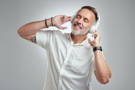 This song lifts my spirit like no other. Studio shot of a mature man wearing headphones against a...