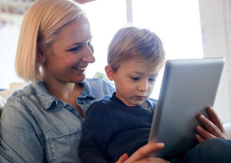 Childhood through the digital age. Cropped shot of a mother and son using a digital tablet together at home.の写真素材