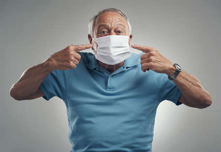 This is how you wear a face mask. Shot of an older man wearing a protective face mask in a studio...