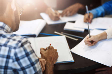 They have a big test to study for. Closeup shot of university students working in the library on...