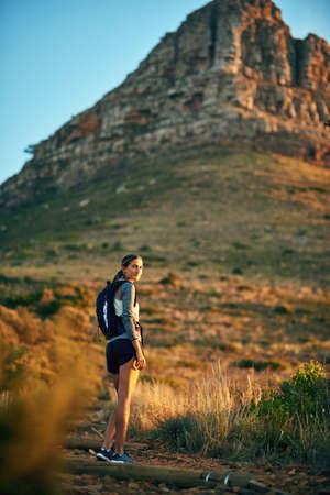 Adventure lies this way. Portrait of a young woman out on a hike through the mountains.