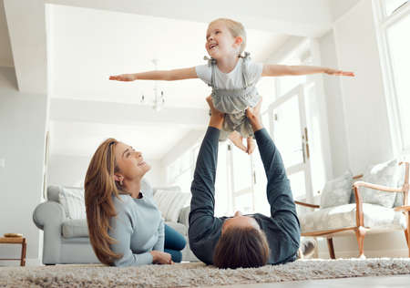 Daddys little girl. Shot of a family bonding playfully on the lounge floor together.の写真素材