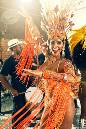 Let the beat take you away. Cropped portrait of a beautiful samba dancer performing at Carnival with her band.の写真素材