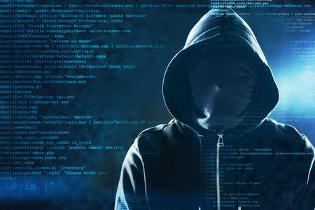 How safe are you online. Shot of an unidentifiable computer hacker posing against a dark background.