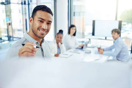 This is what were discussing today. Shot of a young businessman writing on a board during a meeting...