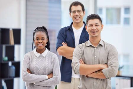 Were the ones who make things happen. Shot of a diverse group of businesspeople standing together in the office with their arms folded.の写真素材