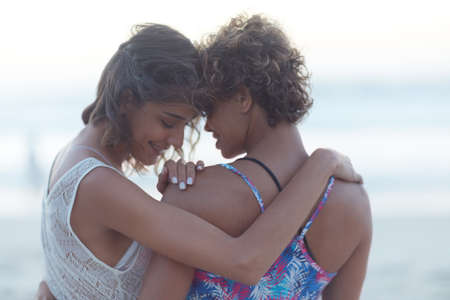 Youre the only one I want to be with. Shot of two young women enjoying themselves at the beach.の写真素材