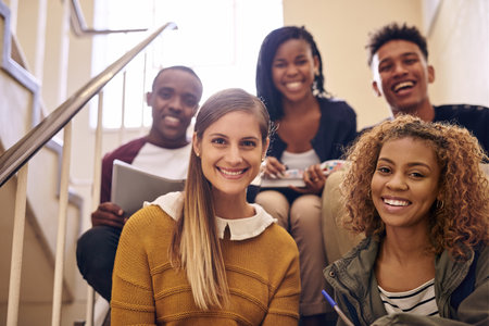 This is what campus life is all about. Cropped portrait of a group of young university students sitting on their campus staircase.の写真素材