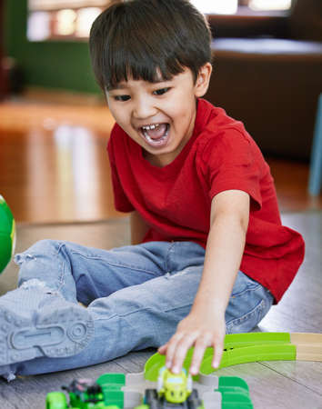 Little boys simply love trains, planes, trucks and cars. Shot of an adorable little boy playing with...