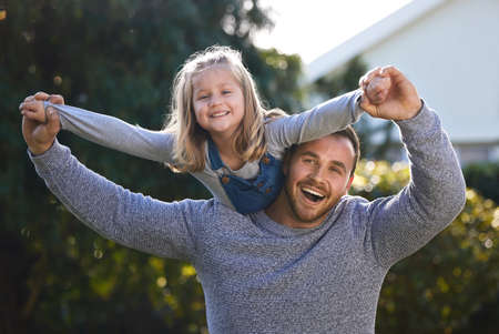 We always make time for fun and play. Portrait of a little girl having fun with her father outdoors.の写真素材