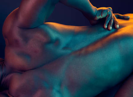 Muscles like his make you want to work out. Shot of a muscular man posing against a studio background.の写真素材