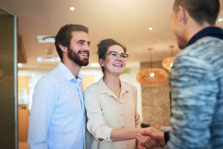 Its always a bonus to extend your business network. Shot of two businesspeople shaking hands in an office.の写真素材