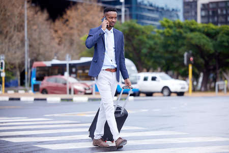 Success is walking from failure to victory. Shot of a young businessman walking and using a phone in...