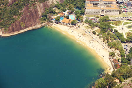 Great day for lounging on the beach. Cropped shot of a city on the coastline with mountains surrounding it.の写真素材